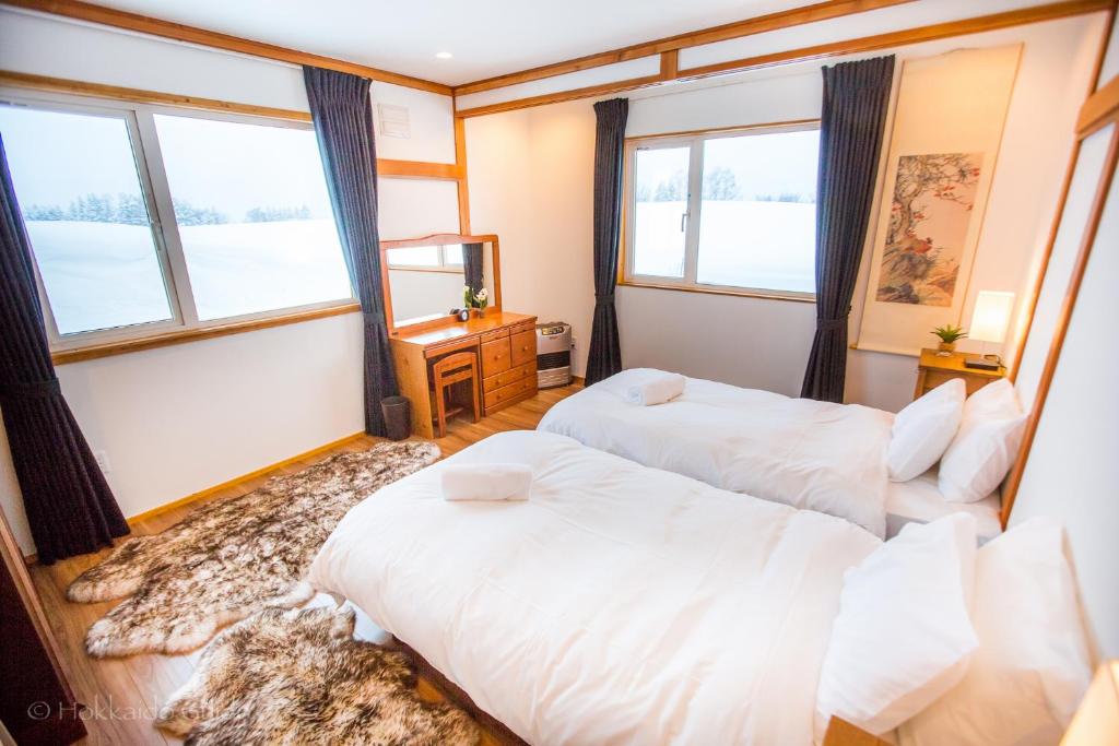 two beds in a room with two windows at RUSUTSU HOLIDAY CHALET in Rusutsu