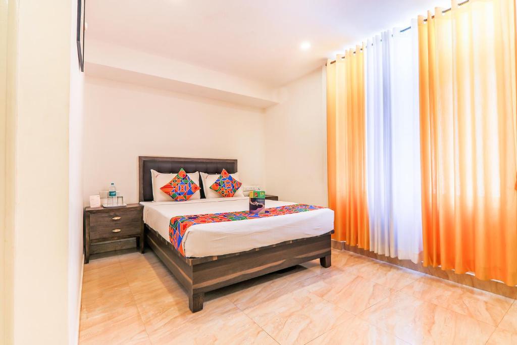 um pequeno quarto com uma cama e uma janela em FabHotel Oakwey Inn Indiranagar em Bangalore