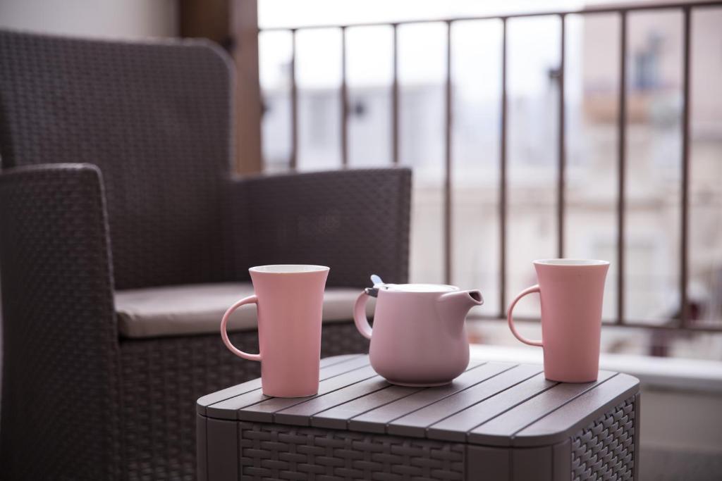 雅典的住宿－Dream penthouse2，坐在椅子旁边的桌子上,两只粉红色的杯子