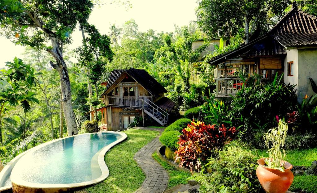a resort with a swimming pool and a house at Prashanti Bali in Ubud