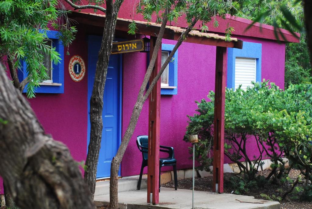 a pink and blue house with a chair in front of it at Mizra Guest House in Mizra‘