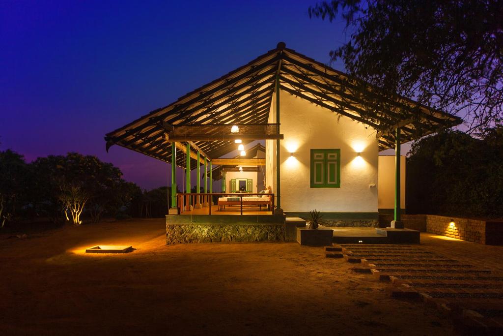 ein kleines Gebäude mit einer Veranda in der Nacht in der Unterkunft Nil Sisila Beach Resort Yala in Yala