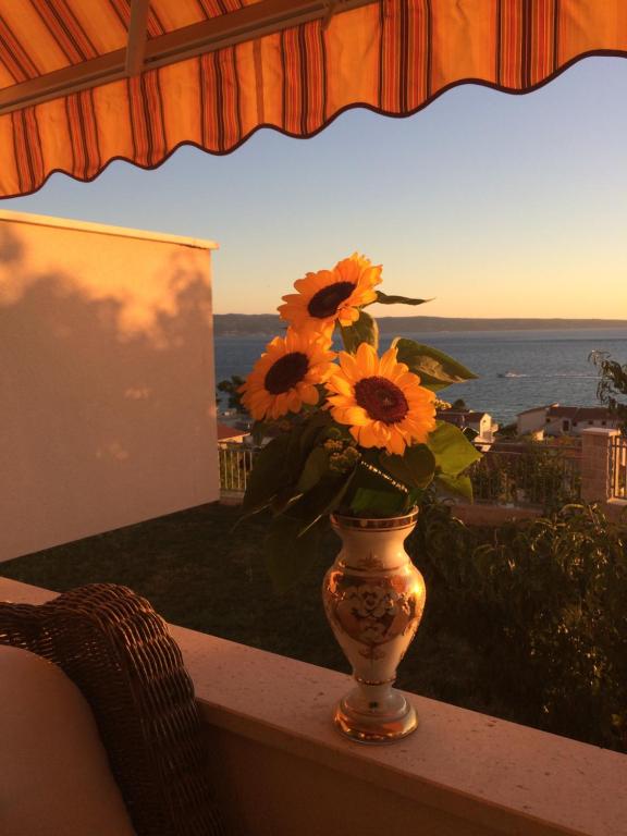 un jarrón lleno de girasoles sentado en una mesa en Apartments Rakuljic, en Podstrana