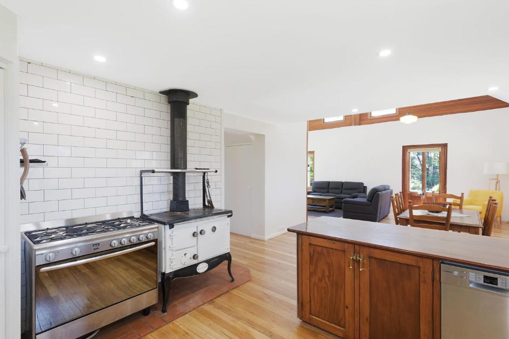 a kitchen with a stove and a living room at 275 Ridge Road Central Tilba in Central Tilba