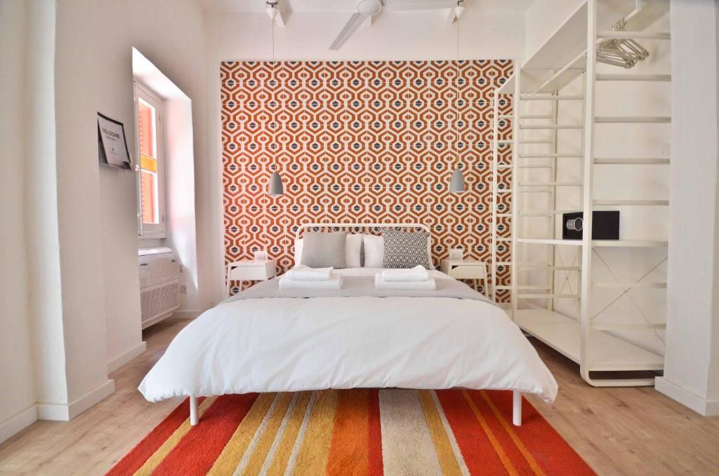 Un dormitorio con una gran cama blanca y una pared estampada en Eight Point Living 34B, en Birgu