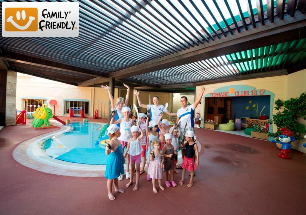 a group of children standing in front of a swimming pool at Limak Atlantis Deluxe Hotel Belek in Belek