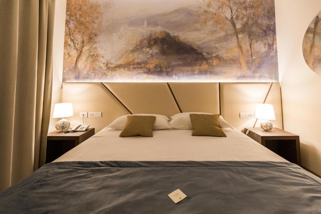een slaapkamer met een groot bed met 2 lampen bij Villa Cavalletti Camere in Grottaferrata