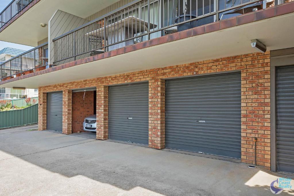 une rangée de portes de garage sur un bâtiment en briques dans l'établissement Pacific Pines Unit 6, à Narooma