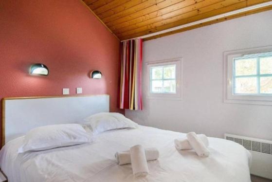 a bedroom with a white bed with two towels on it at La bulle de Lily in Moliets-et-Maa
