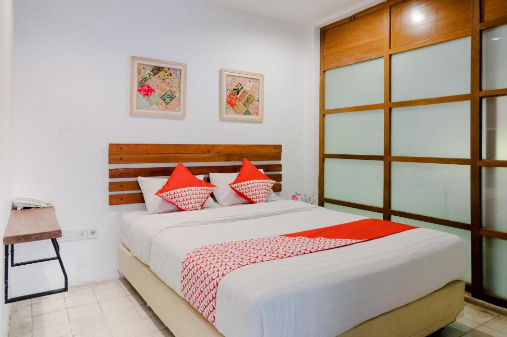 a bedroom with a large bed with red pillows at Augustina Home in Malang