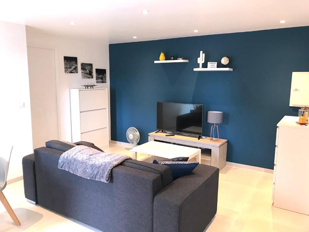 a living room with a couch and a tv at T2 Moderne avec jardin in Rayol-Canadel-sur-Mer