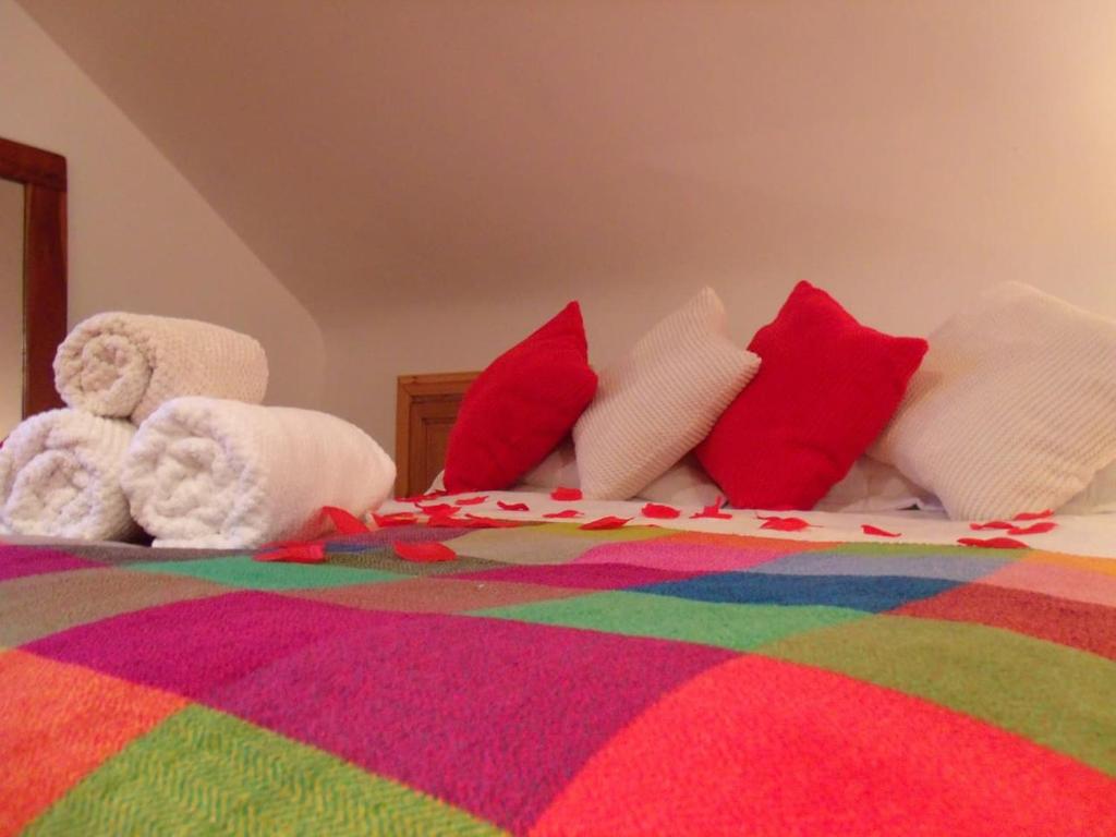 Una cama con muchas almohadas y un osito de peluche en tranquil apartment near Kenmare en Lomanagh