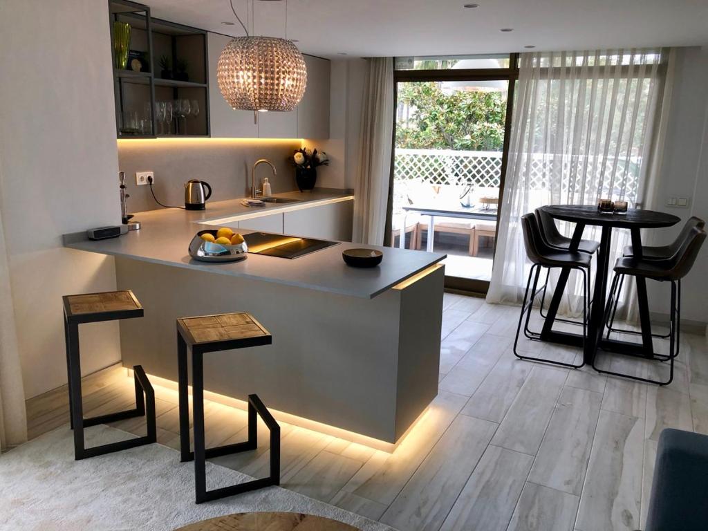 una cucina con bancone, due sgabelli e tavolo di Luxury apartment in La Isla, walking distance to Puerto Banus a Marbella