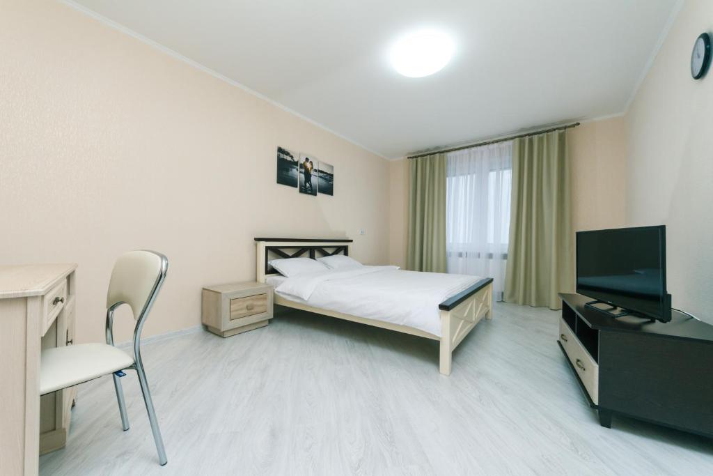 Schlafzimmer mit einem Bett, einem Schreibtisch und einem TV in der Unterkunft Видовая квартира Yaroslavichi-2 in Wyschhorod