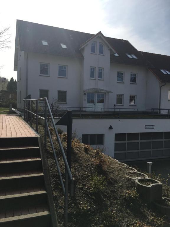 Un grand bâtiment blanc avec des escaliers se trouve juste devant. dans l'établissement Fewo Ostseequartett Wohnung 10, à Zinnowitz