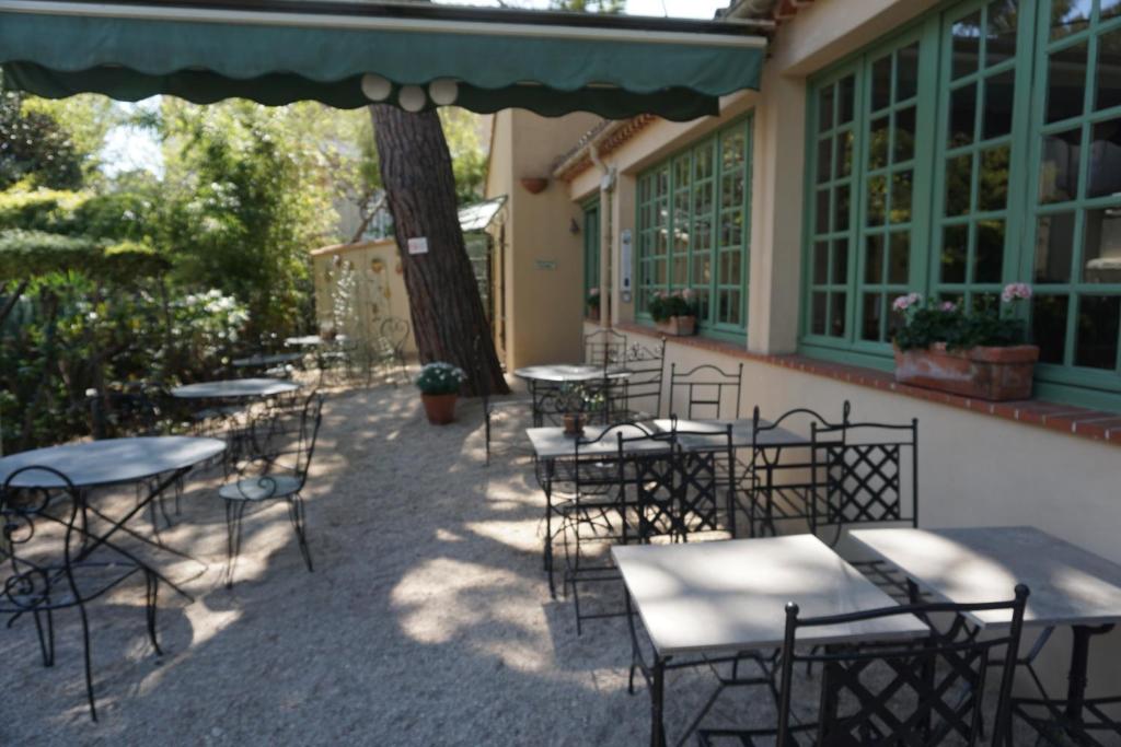 a group of tables and chairs outside of a building at Hotel Le Ponteil in Antibes