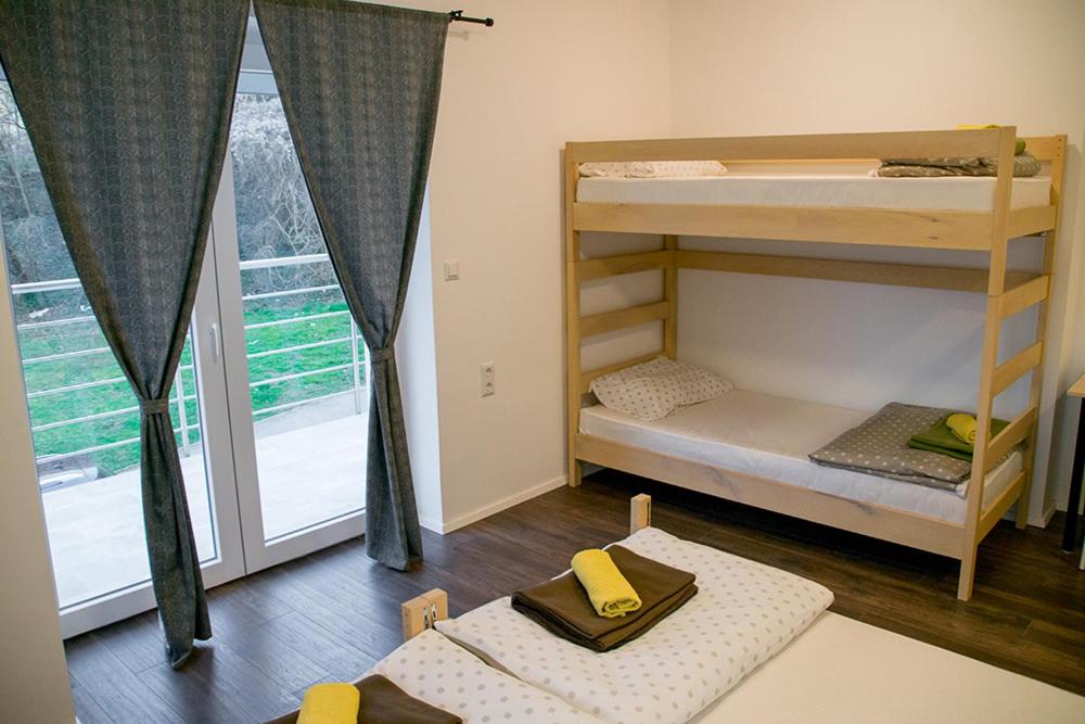 a room with two bunk beds and a window at Wine Hill Hostel in Desinić