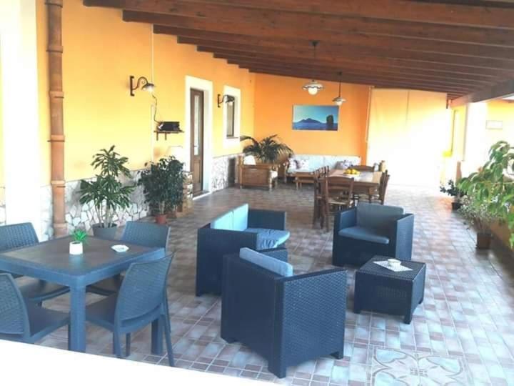 un patio con mesas y sillas y una zona de comedor. en Case Vacanze Villa Lory, en Malfa