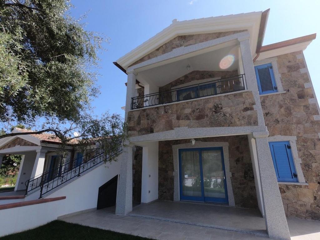 a house with a balcony on the side of it at Villino Blu Mare in San Teodoro