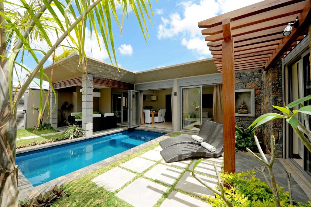 a swimming pool in a backyard with a house at Athena Villas by Fine & Country in Grand Baie