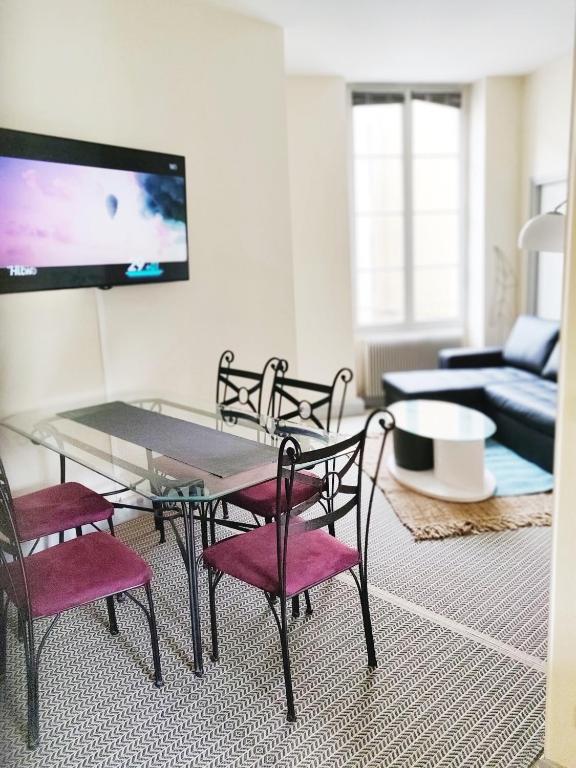 un salon avec une table en verre et des chaises dans l'établissement Chez Fanny - appartement de qualité hypercentre Cahors, à Cahors
