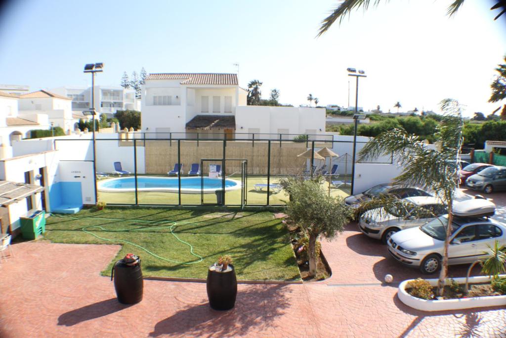a view of a swimming pool in a parking lot at Apartamentos La Palmera in Conil de la Frontera
