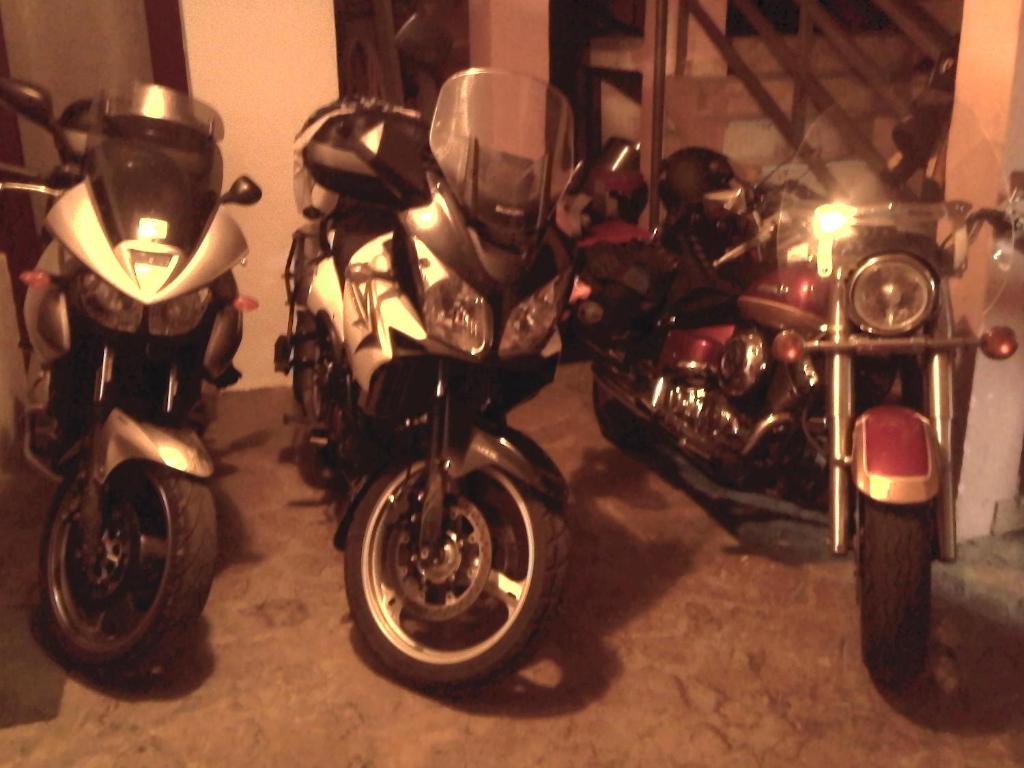 een groep motorfietsen geparkeerd in een garage bij Apartments & Hostel Zdrava Hrana in Mostar