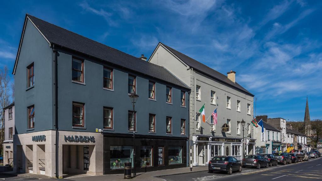 a row of buildings on a street with parked cars at Clew Bay Hotel in Westport