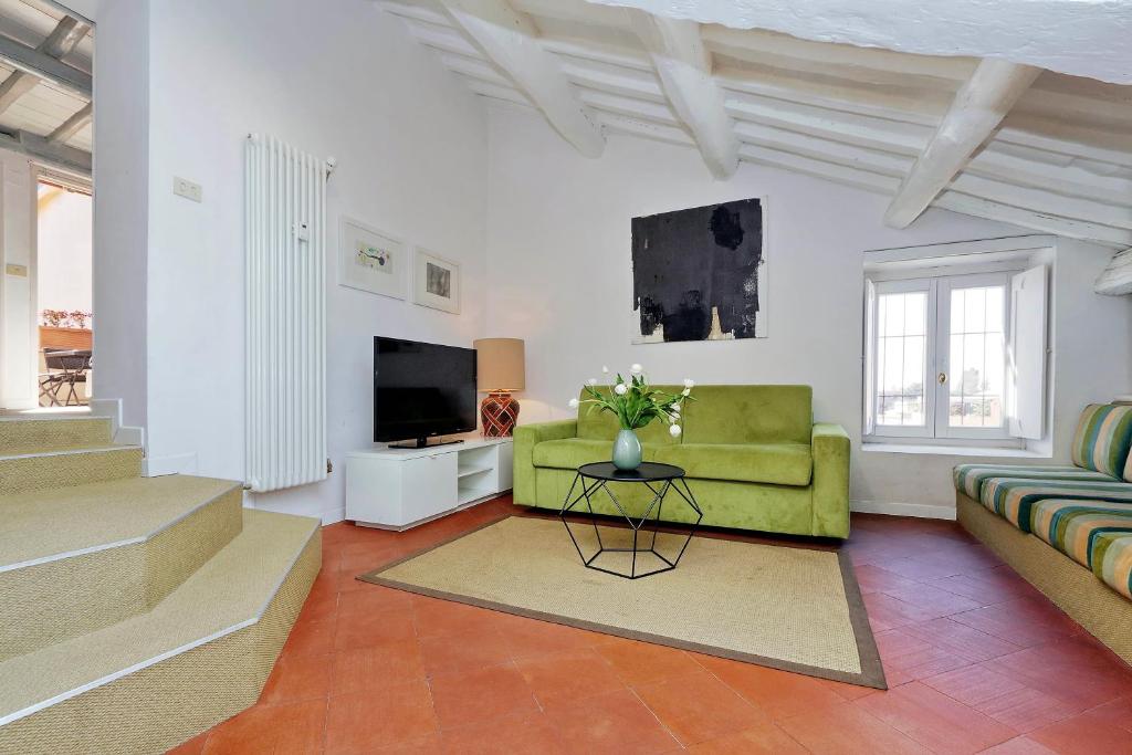 sala de estar con sofá verde y TV en Monti Charme - My Extra Home, en Roma