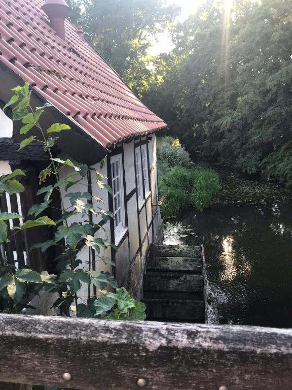 una pequeña casa con escaleras junto a un río en Das Mühlchen, en Ladbergen