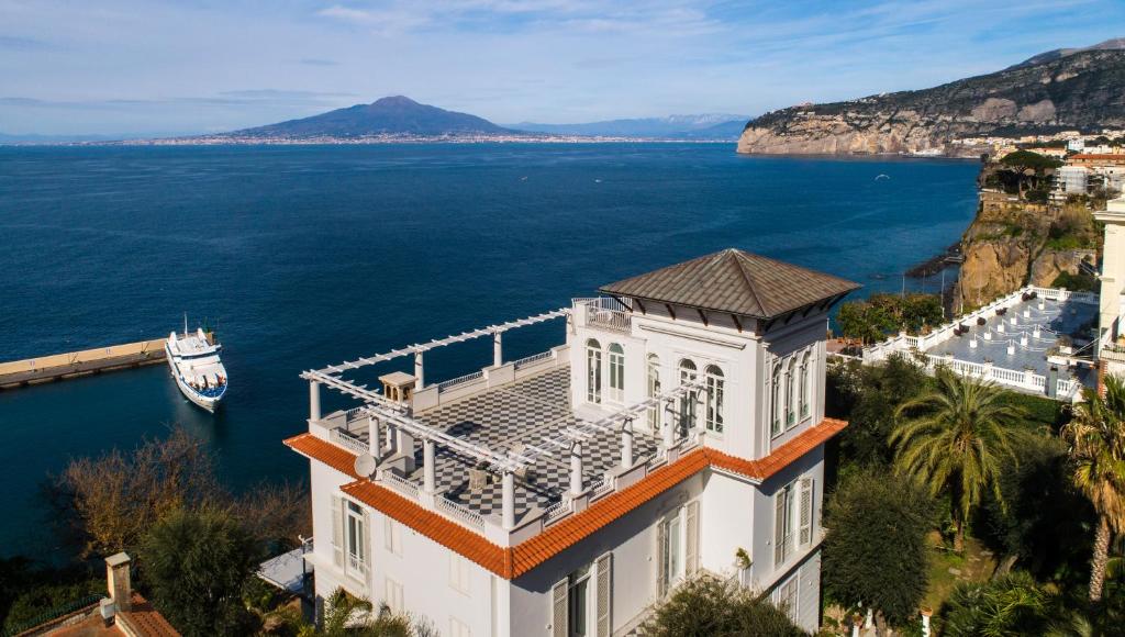un edificio con balcón en la parte superior junto al agua en Villa Silvana Relais, en Sorrento
