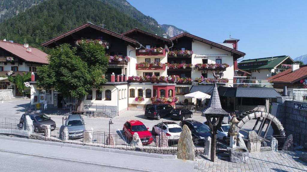 un grand bâtiment avec des voitures garées dans un parking dans l'établissement Hotel Alpenrose, à Pertisau