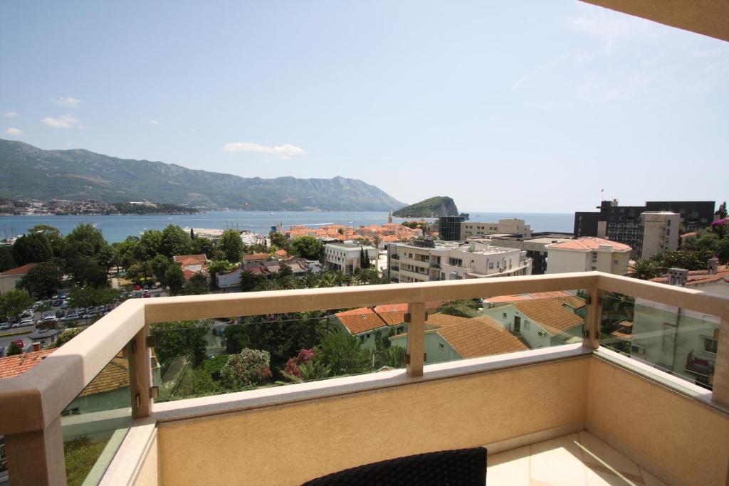 balcón con vistas al agua y a los edificios en The Old Town Terrace Apartments, en Budva