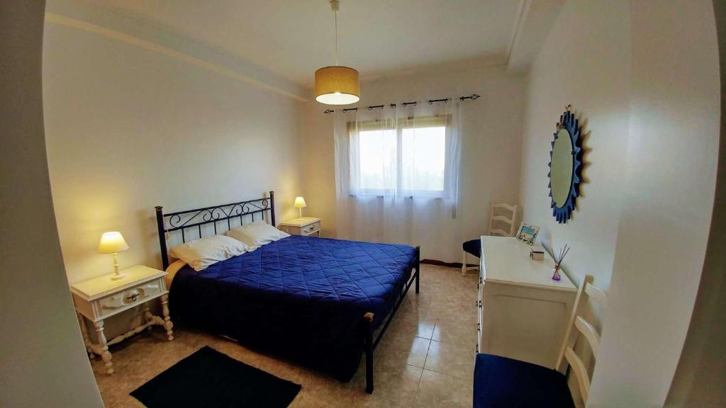 a bedroom with a blue bed and a desk at Casa Carmo in Gafanha da Vagueira