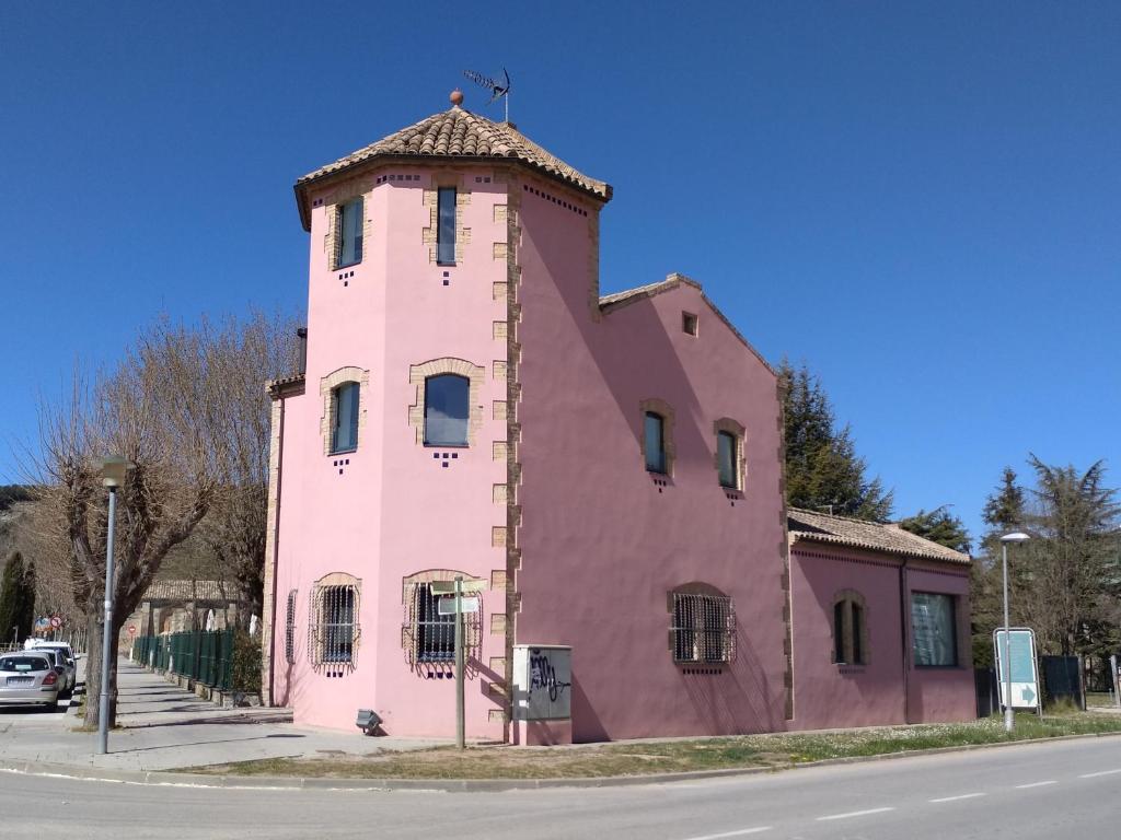 ein rosafarbenes Gebäude an der Straßenseite in der Unterkunft Torre de la Ferrería in Tona