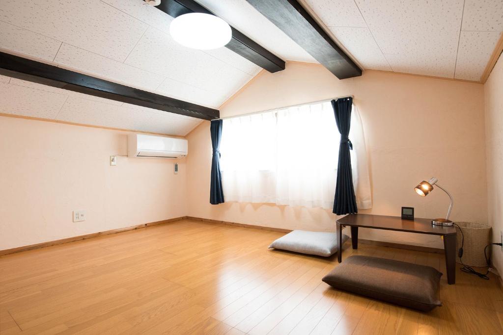 um quarto vazio com uma mesa e uma janela em グローバルリゾート宮島 天神ハウス em Miyajima