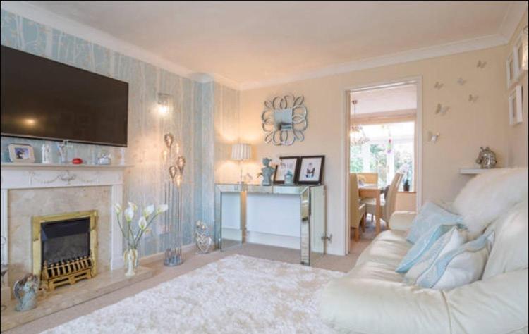 a living room with a white couch and a fireplace at Comfy private room in shared house in Cambridge