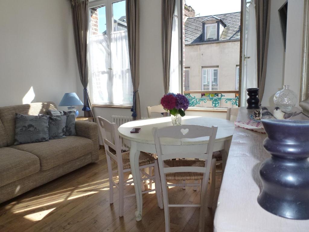 a living room with a white table and chairs at Le Charme à la Française in Honfleur