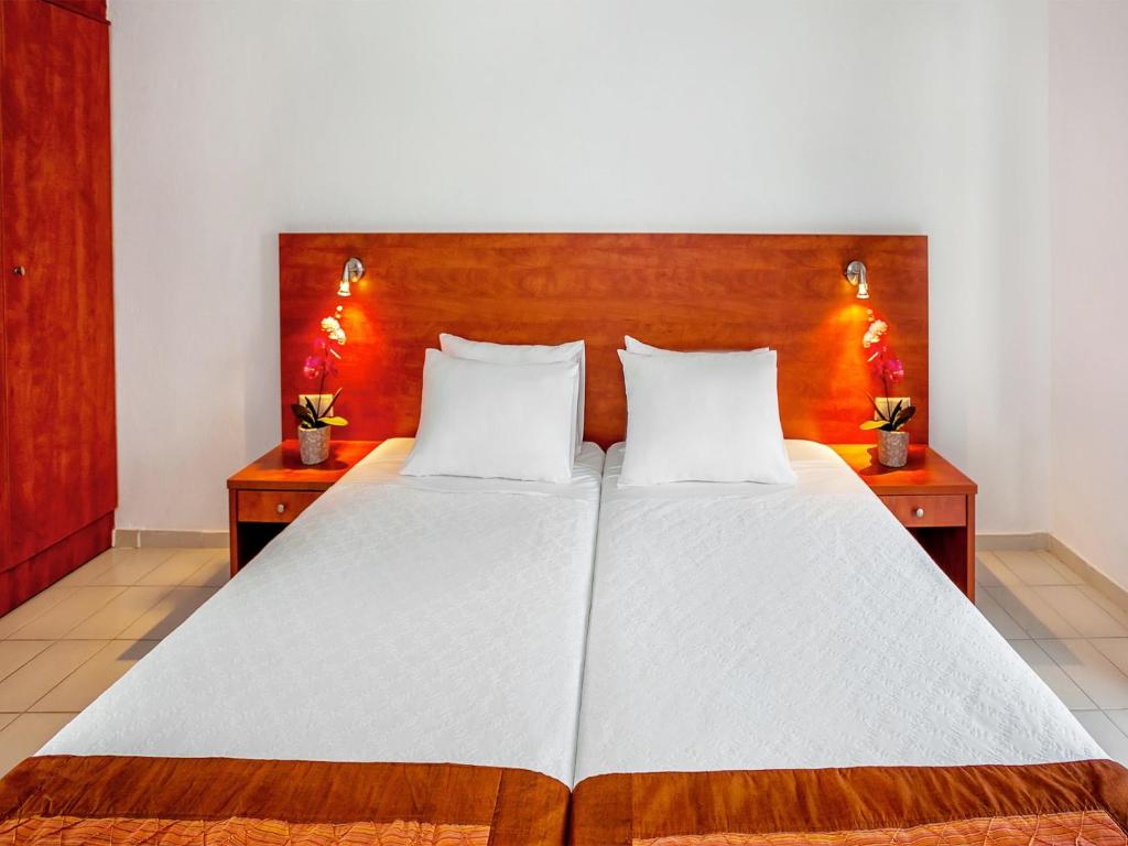 Postel nebo postele na pokoji v ubytování Xenios Dolphin Beach Hotel