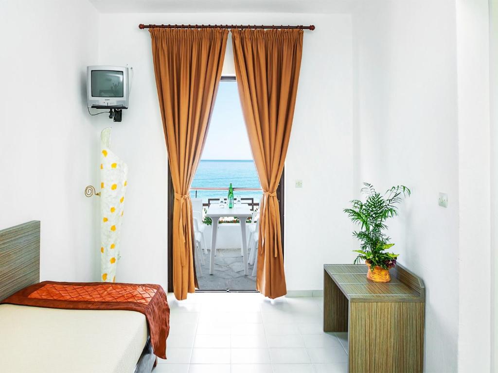 TV a/nebo společenská místnost v ubytování Xenios Dolphin Beach Hotel