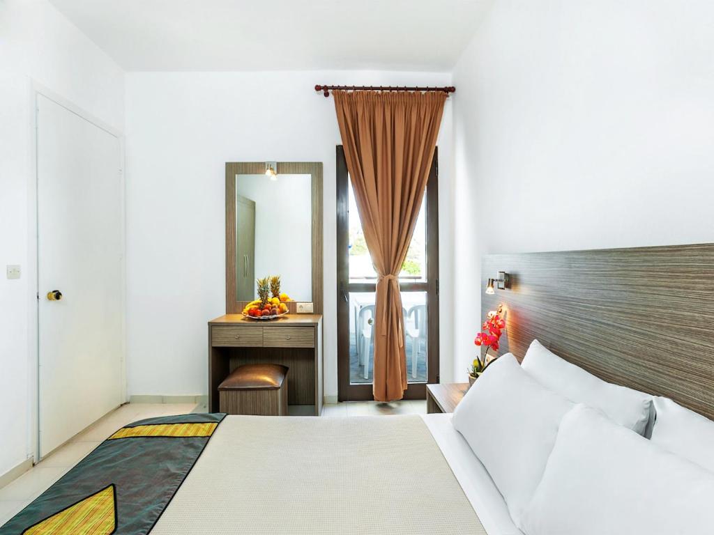 Postel nebo postele na pokoji v ubytování Xenios Dolphin Beach Hotel