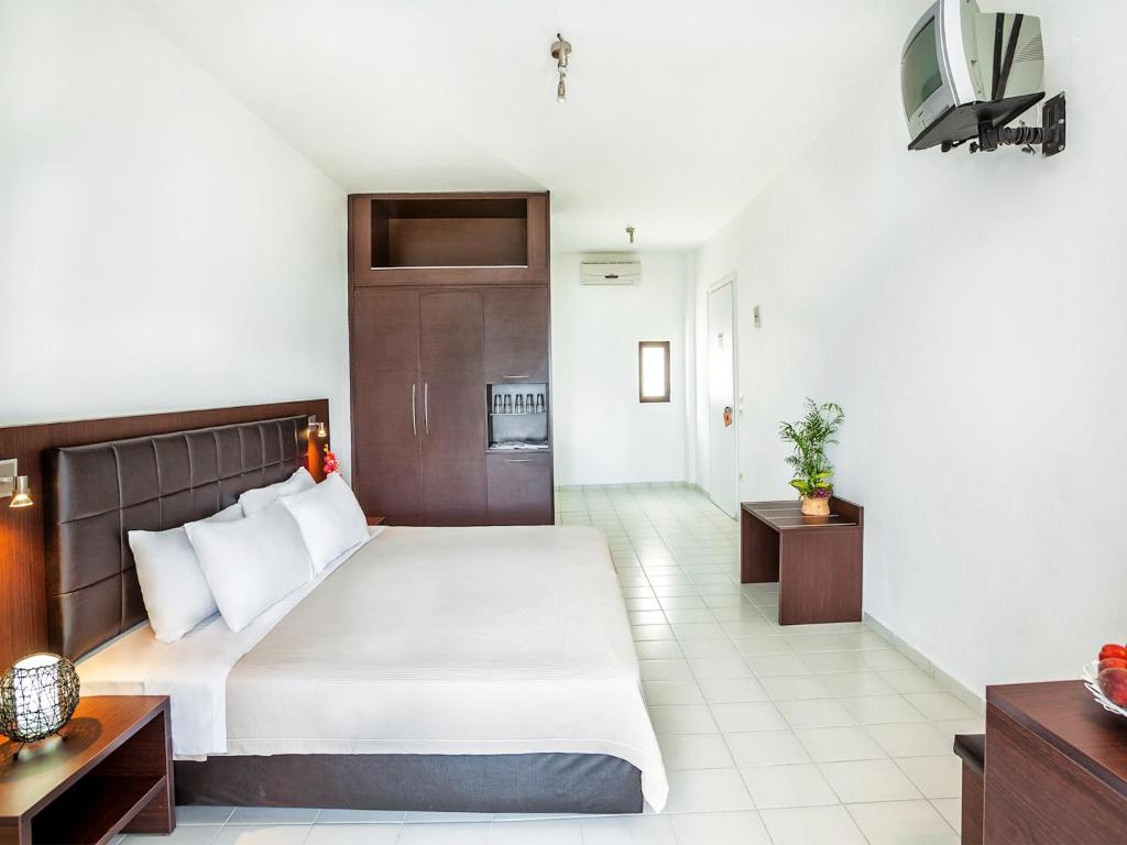 Postel nebo postele na pokoji v ubytování Xenios Dolphin Beach Hotel