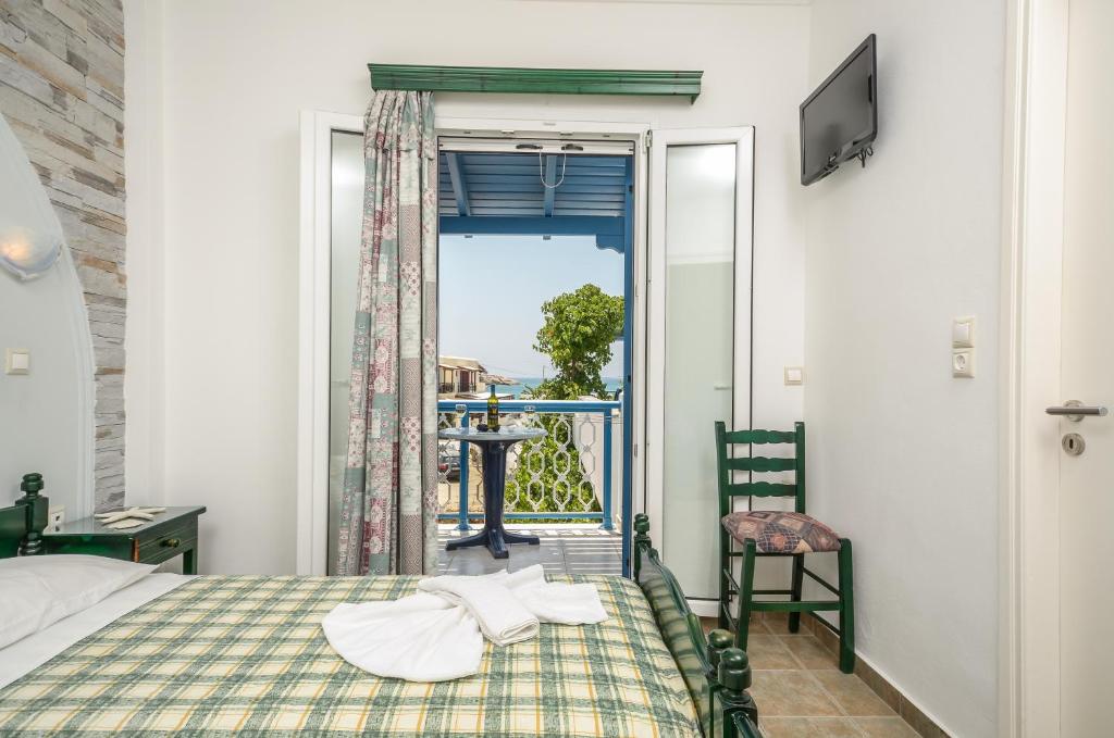 um quarto com uma cama e vista para uma varanda em Polemis Studios & Apartments em Agia Anna (Naxos)