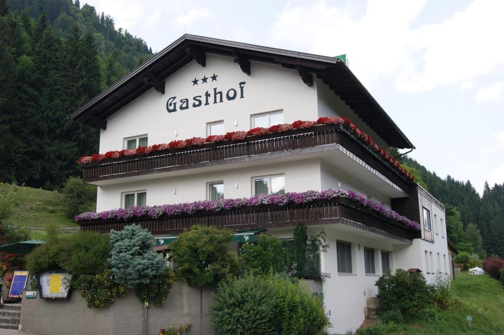 um edifício com flores ao lado em Gasthof Pension Leitner em Wildbad Einöd