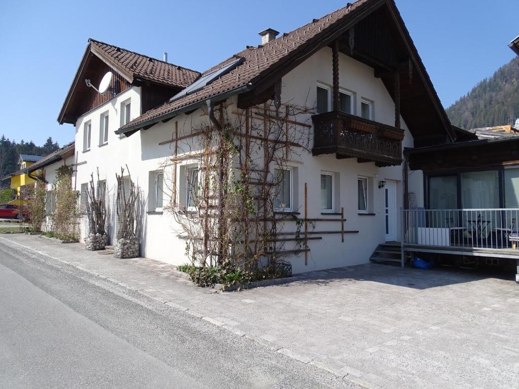 Ein weißes Haus an der Seite einer Straße in der Unterkunft Ferienwohnung Stegmühle in Faistenau