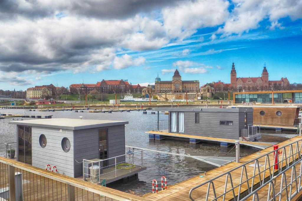 un par de edificios sobre un cuerpo de agua en Hausboot - Domy na wodzie - Houseboat Porta Mare - Odradream, en Szczecin