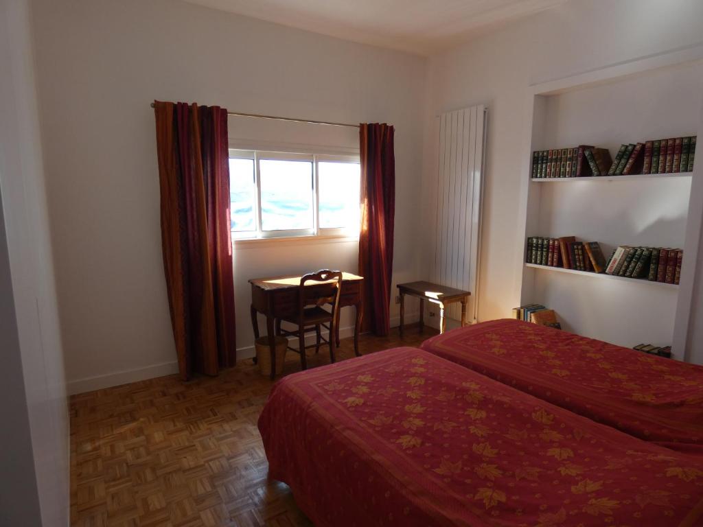 una camera con due letti, un tavolo e una finestra di Maison Basque a Biarritz