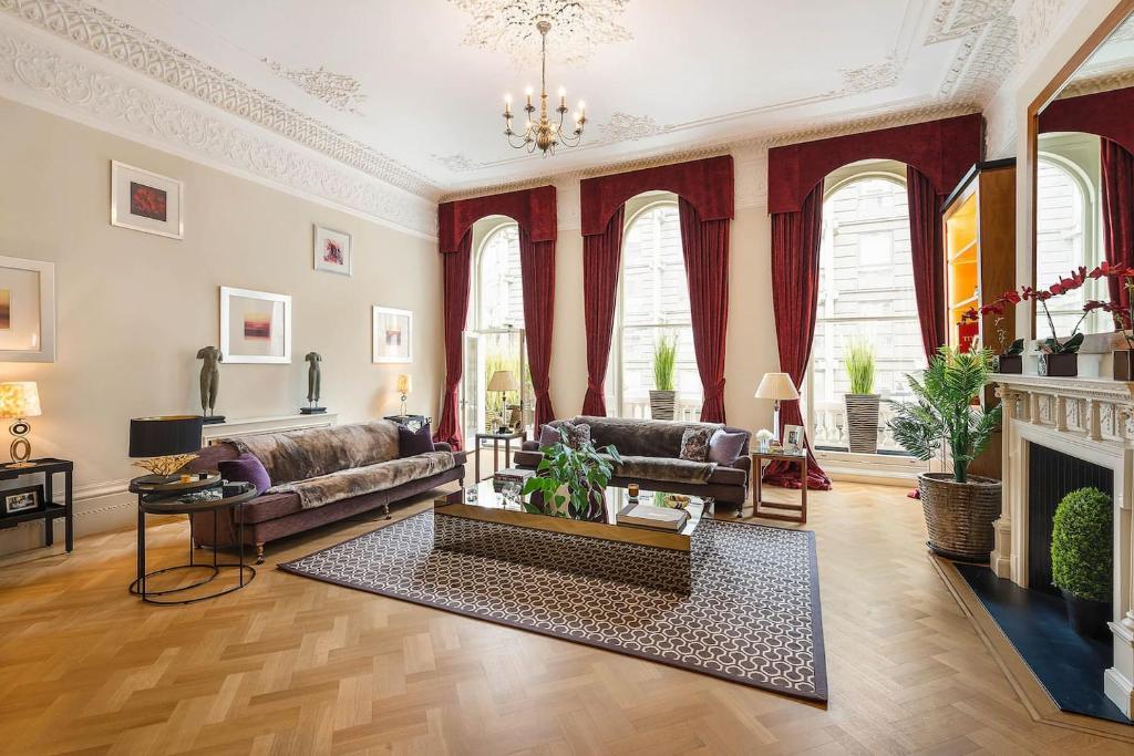 a living room with a couch and a fireplace at Grand Ambassadorial Duplex Apartment Hyde Park in London