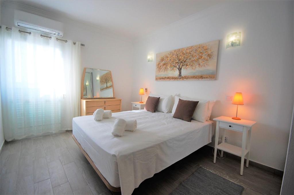 a bedroom with a large white bed with two lamps at Apartment MargemSul - Pool - Beach - Free Wifi - Air Con in Albufeira