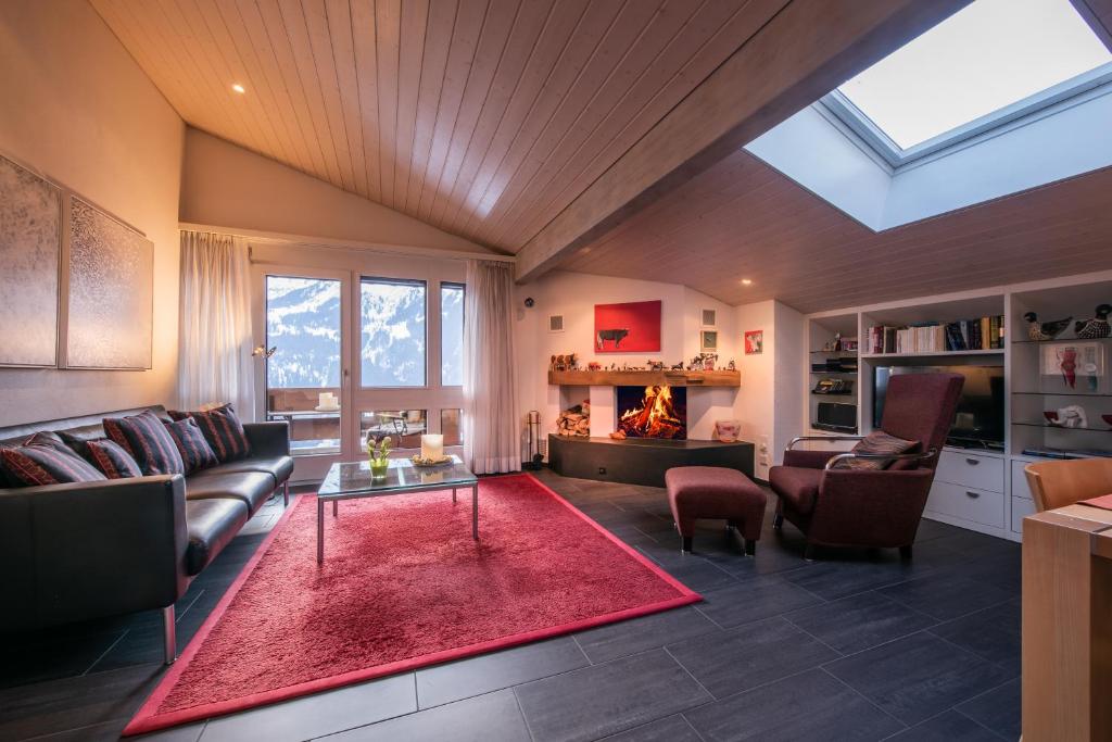 a living room with a couch and a fireplace at Chalet Primula Penthouse in Wengen